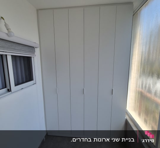 ארון קיר לבן בגובה מלא עם דלתות ציר מותקן בנישה
